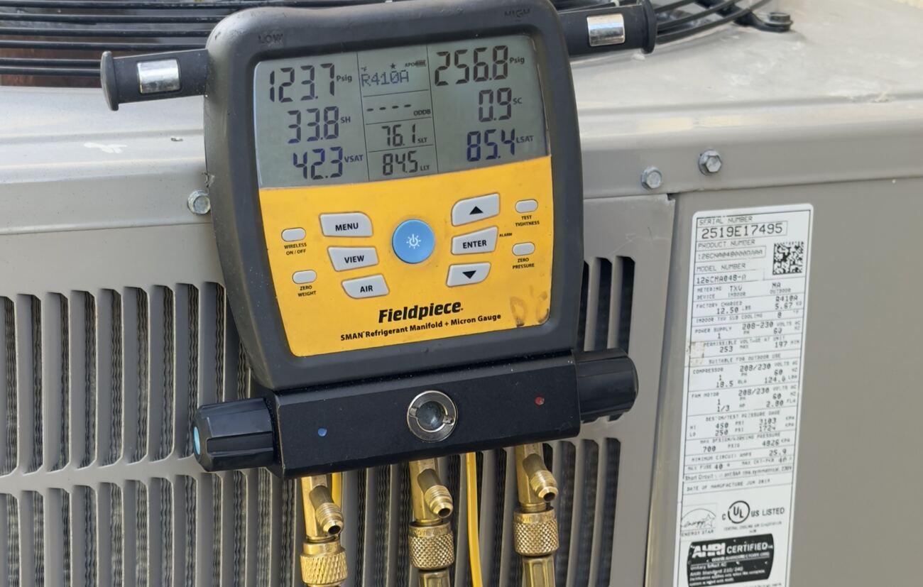 Digital refrigerant gauges reading pressures on a condenser